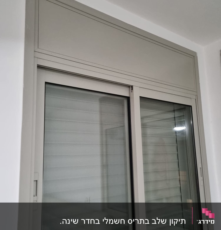 חלון עם תריסים סגורים במסגרת לבנה